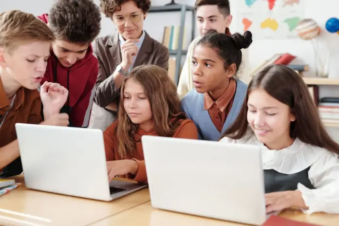 Estudantes em sala de aula usando laptop durante piloto de IA na educação