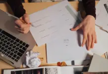 Como testar uma ferramenta de IA antes de adotá-la no trabalho Pessoa revisando anotações e documentos ao lado de um notebook